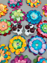 Load image into Gallery viewer, Cremation memorial art, such as Day of the Dead Spirit Pieces, provide a unique way to keep a loved one close to your heart. Handcrafted with care, each piece of artwork is specially tailored to the individual, providing a lasting reminder of those who are dearly missed. On altars and ofrendas, these pieces make a beautiful addition. Composed with meticulous attention to detail, these mini polymer clay skulls feature hand sculpted dark red roses and leaves. H 1 1/2” x W 1 1/2” x D 3/4”