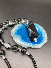 Load image into Gallery viewer, This black agate natural stone necklace features a unique rectangular pyramid shape and multi-colored glass beads. Perfect for all kinds of looks, from cocktail attire to shabby chic to elegant goth styles, this necklace is as versatile as it is stylish and will complete any outfit. The set includes matching earrings, making it a must-have addition to any jewelry collection. Measurements: Necklace is 18 1/2”