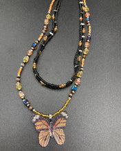 Load image into Gallery viewer, Sterling silver butterfly pendant is molded from a basil leaf and is painted in strikingly bright orange and black. The first two strands contain two-hole black and silver beads to retain a more "collar" shape. They are primarily black beads with larger orange beads. The third and slightly longer strand has bright gold and orange square shaped glass beads along the black beads to compliment the monarch butterfly wings. Perfect for your summer look! Necklace is 14” adjustable up to 18" - pendant is 1”