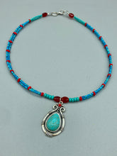 Load image into Gallery viewer, This captivating Southwestern style necklace features a two-strand design of bold and vibrant turquoise and red glass beads. At the center, a bright turquoise pendant is framed in a distinctive design. Measurements: Necklace is 16 1/2 ” adjustable up to 18"