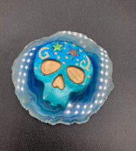 Load image into Gallery viewer, Perfect item to add to your fridge, locker, cubicle, toolbox or dishwasher. This handcrafted skull statuette features shimmering metallic and vivid blue hues, metallic gold stars, and intricate detailing. The skull's forehead is adorned with a glittering hematite star bead.  Measurements: H 1 1/2” x W 1 1/2” x D 3/4”