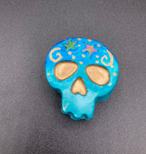 Load image into Gallery viewer, Perfect item to add to your fridge, locker, cubicle, toolbox or dishwasher. This handcrafted skull statuette features shimmering metallic and vivid blue hues, metallic gold stars, and intricate detailing. The skull's forehead is adorned with a glittering hematite star bead.  Measurements: H 1 1/2” x W 1 1/2” x D 3/4”