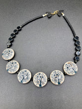 Load image into Gallery viewer, This eye-catching, sizable and conspicuous black stone beads create a powerful accent piece. Crafted of reconstituted quartzite lentil beads in a tree pattern, these beads measure approximately 24mm. To enhance their effect, a round necklace of black glass beads is included. Perfect for casual or formal wear, this necklace adds an elegant finish to any ensemble. Matching earrings feature white rose reconstituted quartzite beads, completing the set. Measurements: Necklace is 18 " in length