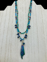 Load image into Gallery viewer, This celestial and galaxy goddess necklace features two strands of glass beading and a captivating Kyanite wired stone pendant. Its mixture of shimmering purples, blues, greens, and golds is truly striking and provides an alluring look like no other. Add this bold and beautiful jewelry piece to your collection today for a statement look that truly stands out. Necklace is 15” in length, can be adjusted to 18"