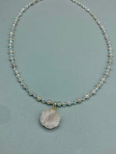 Load image into Gallery viewer, This elegant necklace is adorned with a beautiful rose quartz pendant featuring an intricate floral cutout, complemented by small round rose quartz beads with an iridescent glass finish. Measurements: Necklace is 18 1/2”