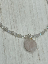 Load image into Gallery viewer, This elegant necklace is adorned with a beautiful rose quartz pendant featuring an intricate floral cutout, complemented by small round rose quartz beads with an iridescent glass finish. Measurements: Necklace is 18 1/2”