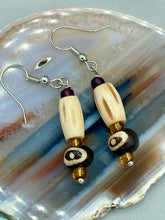 Load image into Gallery viewer, This set of earrings features a cylinder bone bead and round bone bead with eye design and a gold-tone glass bead. Neutral colors allow for versatile styling; the resulting look is sure to be unique.  Measurements: 1 1/2 ” in length