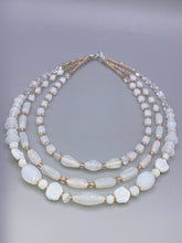 Load image into Gallery viewer, This necklace is the perfect finishing touch to any outfit. Featuring three strands of white and gold glass beads for a classic and elegant look. The small clear and gold glass beads add a touch of sophistication. Adjustable for a comfortable fit. Measurements: Necklace is 17” in length, can be adjusted up to 19 1/2"