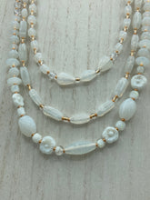 Load image into Gallery viewer, This necklace is the perfect finishing touch to any outfit. Featuring three strands of white and gold glass beads for a classic and elegant look. The small clear and gold glass beads add a touch of sophistication. Adjustable for a comfortable fit. Measurements: Necklace is 17” in length, can be adjusted up to 19 1/2"