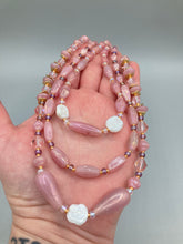 Load image into Gallery viewer, This three-strand beaded necklace is crafted with iridescent dusty rose glass, along with white, gold, pink, and iridescent purple beads for an eclectic mix of colors, tones, and textures. Perfect for any occasion, this gorgeous statement piece will add the finishing touch to your look. Measurements: Necklace is 17” in length, can be adjusted up to 19"