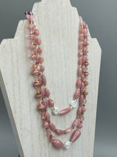 Load image into Gallery viewer, This three-strand beaded necklace is crafted with iridescent dusty rose glass, along with white, gold, pink, and iridescent purple beads for an eclectic mix of colors, tones, and textures. Perfect for any occasion, this gorgeous statement piece will add the finishing touch to your look. Measurements: Necklace is 17” in length, can be adjusted up to 19"