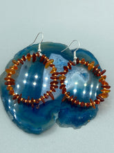 Load image into Gallery viewer, These hoop earrings feature natural amber stone chips and gold glass beads for an elegant, nature-inspired look. Measurements: 2" length and 2” in width