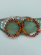 Load image into Gallery viewer, These hoop earrings feature natural amber stone chips and gold glass beads for an elegant, nature-inspired look. Measurements: 2" length and 2” in width