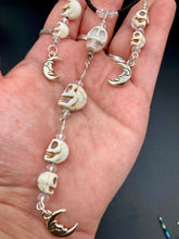 Load image into Gallery viewer, Massive beautiful bold cascade of skulls goth witchy necklace is the ultimate statement piece to add to your jewelry collection! Three strands full of howlite skull beads draping down with smiling crescent moon charms. Chingona, Cabrona, Latina Chicana, Goth, Vampire Goth, Dark Witchy Style. You can dress these up or down, it will definitely give your outfit a unique look.  Measurements: 17” adjustable up to 19" in length