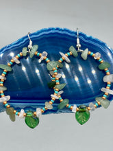 Load image into Gallery viewer, These handmade hoop earrings feature natural Aventurine and White Moon Stone chips along with turquoise and gold glass beads. The light green-toned pressed glass leaf charm beautifully shimmers with iridescent hues of gold, purple, blue, and pink. Measurements: 2" length
