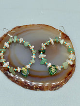 Load image into Gallery viewer, These handmade hoop earrings feature natural Aventurine and White Moon Stone chips along with turquoise and gold glass beads. The light green-toned pressed glass leaf charm beautifully shimmers with iridescent hues of gold, purple, blue, and pink. Measurements: 2" length