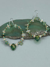 Load image into Gallery viewer, These handmade hoop earrings feature natural Aventurine and White Moon Stone chips along with turquoise and gold glass beads. The light green-toned pressed glass leaf charm beautifully shimmers with iridescent hues of gold, purple, blue, and pink. Measurements: 2" length