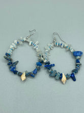 Load image into Gallery viewer, These earrings boast a beautiful combination of natural lapis and white moon stone chip stones, artfully inlaid with gold glass beads in a hoop formation. Dainty conch shells add a subtle touch of nature for a look that perfectly captures the beach vibes of summer. An ideal choice to complement any style. Measurements: 2 1/4" length