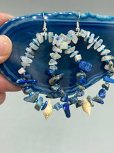 Load image into Gallery viewer, These earrings boast a beautiful combination of natural lapis and white moon stone chip stones, artfully inlaid with gold glass beads in a hoop formation. Dainty conch shells add a subtle touch of nature for a look that perfectly captures the beach vibes of summer. An ideal choice to complement any style. Measurements: 2 1/4" length