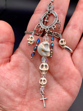 Load image into Gallery viewer, Large Chandelier Style Earrings Howlite Skull Beads Silver Plated Crosses. Ultimate Chingona, Cabrona, Latina Chicana, Goth, Vampire Goth, Dark Witchy Style. You can dress these up or down, it will definitely give your outfit a unique look. Cascade of dangling skulls and crosses have plenty of fun movement.  Measurements: 4” in length