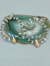 Load image into Gallery viewer, Dainty conch shells and natural white moon stone chips, these dark silver and gold glass beaded hoop earrings are the perfect accessory for any nature-loving, beach-themed outfit. Their versatility allows them to easily complement any outfit. Measurements: 2 1/4" length