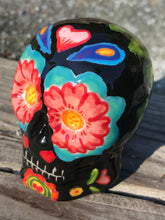 Load image into Gallery viewer, This Mini Day of the Dead Black Ceramic Sugar Skull is a stunning, nature-inspired piece of hand painted art. Featuring elements from a photography I took of a flower floating in a fountain at Grounds for Sculpture, this unique work of art is ideal for honoring memories of those who have passed. Its beautiful mausoleum, statues, and stained glass elements make it the perfect choice for any special occasion. Measurements: H 2 3/4” x W 2” x D 2”