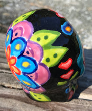 Load image into Gallery viewer, This Mini Day of the Dead Black Ceramic Sugar Skull is a stunning, nature-inspired piece of hand painted art. Featuring elements from a photography I took of a flower floating in a fountain at Grounds for Sculpture, this unique work of art is ideal for honoring memories of those who have passed. Its beautiful mausoleum, statues, and stained glass elements make it the perfect choice for any special occasion. Measurements: H 2 3/4” x W 2” x D 2”