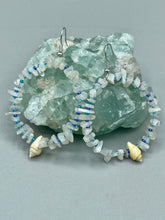 Load image into Gallery viewer, Crafted with natural white moonstone chips, blue glass beads and tiny conch shells, these hoop earrings are a bohemian statement piece. Perfect for nature and beach lovers, they add a touch of shabby chic to any summer look. Measurements: 2" length