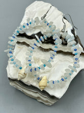 Load image into Gallery viewer, Crafted with natural white moonstone chips, blue glass beads and tiny conch shells, these hoop earrings are a bohemian statement piece. Perfect for nature and beach lovers, they add a touch of shabby chic to any summer look. Measurements: 2" length