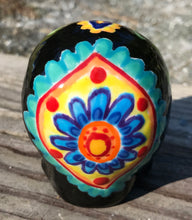 Load image into Gallery viewer, This black ceramic sugar skull, inspired by nature, is adorned with hand-painted floral motifs, hearts, leaves and colorful accents. Its vibrant style and intricate details create a stunning Dia De Los Muertos calavera. Perfect for creating ofrendas to celebrate the Day of the Dead. Measurements: H 2 3/4” x W 2” x D 2”
