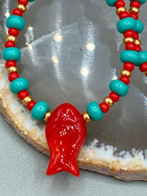 Load image into Gallery viewer, This eye-catching pair of earrings features vibrant fire engine red fish glass beads, accented with small teal, red, and golden glass beads. Each fish bead boasts detailed fins and eyes, creating a bright and captivating piece of jewelry measuring 2" in length.