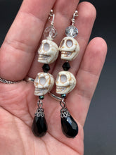 Load image into Gallery viewer, This luxurious design features two large howlite skull beads and a large black teardrop shaped glass bead; perfect for achieving a Chingona, Cabrona, Latina Chicana, Goth, Vampire Goth, Dark Witchy, La Bruja look. This statement jewelry will add a unique touch to any outfit.