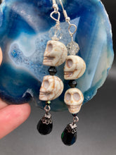 Load image into Gallery viewer, Witchy Vibe, Goth Dark Souls Jewelry, Day Of The Dead, Dia De Los Muertos. Two large howlite skulls beaded earrings are accompanied by iridescent and black teardrop glass beads