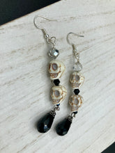 Load image into Gallery viewer, This luxurious design features two large howlite skull beads and a large black teardrop shaped glass bead; perfect for achieving a Chingona, Cabrona, Latina Chicana, Goth, Vampire Goth, Dark Witchy, La Bruja look. This statement jewelry will add a unique touch to any outfit.