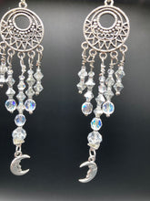 Load image into Gallery viewer, Whimsical Celestial Smiling Crescent Moons Large Chandelier Earrings. Five strands of beautiful clear iridescent glass beads and dangling smiling crescent moon charms. This is perfect for any outfit and will surely stand out. Measurements: 4” in length. Witchy, Whimsical, Goth, Luna Lovers, Crescent Smiling Moons