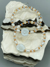 Load image into Gallery viewer, These white floral glass beaded hoop earrings bring a bohemian, shabby-chic, and nature-inspired vibe to any look. Crafted with small iridescent, gold, and white glass beads, they are the perfect accessory for any fashionista who loves beach vibes, summer elements, and chic boho styles. Measurements: 2 1/4" length