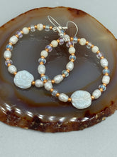 Load image into Gallery viewer, These white floral glass beaded hoop earrings bring a bohemian, shabby-chic, and nature-inspired vibe to any look. Crafted with small iridescent, gold, and white glass beads, they are the perfect accessory for any fashionista who loves beach vibes, summer elements, and chic boho styles. Measurements: 2 1/4" length