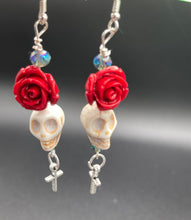 Load image into Gallery viewer, Frida Kahlo Inspired Earrings, Chicana Chingona Chola Style Jewelry. Howlite Skull Bead With Red Quartize Rose Beads. Beautifully and elegant set of earrings captures Frida Kahlo's signature floral crown on her head, dangling silver plated cross gives these earrings some movement. These are a beautiful piece of jewelry to wear for inspiration or a great Dia De Los Muertos jewelry piece. You can dress these up or down, it will definitely give your outfit a unique look. 2 ” in length