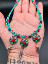 Load image into Gallery viewer, This two-stranded necklace features a vibrant Southwest-inspired design. Hand-beaded turquoise, bright red, and dark green colors, along with silver-plated feather charms, add dynamic movement to the piece. An ideal set for chingona guerrera carbonas, la India princesses, warrior cosplay, and other native-inspired looks. Measurements: Necklace is 15” adjustable up to 18" in length