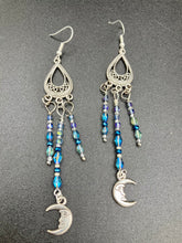 Load image into Gallery viewer, These three-strand chandelier style earrings offer an ornate and eye-catching look with their whimsical blue celestial charm accents adorned with smiling crescent moon designs. Perfect for creating a fairy princess, witchy, or boho aesthetic, they provide plenty of movement and can easily be added to any jewelry collection.  Measurements: 3 1/2” in length