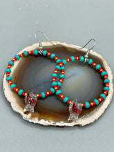 Load image into Gallery viewer, This eye-catching set of earrings features intricately detailed koi fish glass beads, accompanied by smaller teal, red, and gold-hued glass beads. With their bold and vibrant colors, they make a striking statement. Measurements: 2 1/4” in length