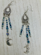 Load image into Gallery viewer, These three-strand chandelier style earrings offer an ornate and eye-catching look with their whimsical blue celestial charm accents adorned with smiling crescent moon designs. Perfect for creating a fairy princess, witchy, or boho aesthetic, they provide plenty of movement and can easily be added to any jewelry collection.  Measurements: 3 1/2” in length