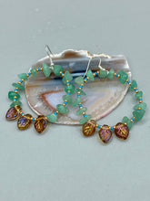 Load image into Gallery viewer, These Aventurine Stone Chip Beaded Hoop Earrings feature natural aventurine stone chips, turquoise, and gold glass beads. The amber-tone pressed glass leaf charm has an iridescent shimmer finish, with subtle accents of gold, purple, blue, and pink. Measurements: 2" length