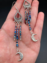 Load image into Gallery viewer, These three-strand chandelier style earrings offer an ornate and eye-catching look with their whimsical blue celestial charm accents adorned with smiling crescent moon designs. Perfect for creating a fairy princess, witchy, or boho aesthetic, they provide plenty of movement and can easily be added to any jewelry collection.  Measurements: 3 1/2” in length