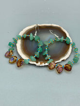 Load image into Gallery viewer, These Aventurine Stone Chip Beaded Hoop Earrings feature natural aventurine stone chips, turquoise, and gold glass beads. The amber-tone pressed glass leaf charm has an iridescent shimmer finish, with subtle accents of gold, purple, blue, and pink. Measurements: 2" length
