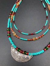 Load image into Gallery viewer, Three strands of Southwestern Style Inspired Adjustable Choker Beaded Necklace features an eye-catching blend of vibrant turquoise, red, green, gold, and yellow glass beads, accented with a wide silver plated tribal pattern pendant. Measurements: Necklace is 15 1/2” adjustable up to 18" in length