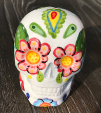 Load image into Gallery viewer, Bring Southwest beauty to any space with this unique ceramic sugar skull art. Hand-painted with bright colors, this piece captures the spirit of Sedona in a Dia de Los Muertos ofrenda. Let this delightful piece evoke the magical beauty of the amazing landscape you'll never forget. H 2 3/4” x W 2” x D 2”