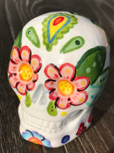 Load image into Gallery viewer, Bring Southwest beauty to any space with this unique ceramic sugar skull art. Hand-painted with bright colors, this piece captures the spirit of Sedona in a Dia de Los Muertos ofrenda. Let this delightful piece evoke the magical beauty of the amazing landscape you'll never forget. H 2 3/4” x W 2” x D 2”