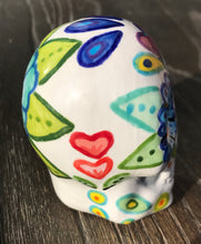 Load image into Gallery viewer, This stunning Mini Dia de Los Muertos Calavera is a one-of-a-kind hand-painted ceramic sugar skull, with an aquatic-inspired color palette. The unique flower on the back of the skull is painted to look like the head of a jellyfish. Display this beautiful piece of art and enjoy the elegance and beauty of its delicate dance. Measurements: H 2 3/4” x W 2” x D 2”