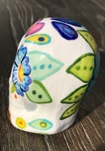 Load image into Gallery viewer, This stunning Mini Dia de Los Muertos Calavera is a one-of-a-kind hand-painted ceramic sugar skull, with an aquatic-inspired color palette. The unique flower on the back of the skull is painted to look like the head of a jellyfish. Display this beautiful piece of art and enjoy the elegance and beauty of its delicate dance. Measurements: H 2 3/4” x W 2” x D 2”